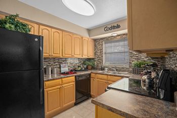 A kitchen with black appliances and wooden cabinets